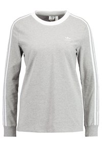 Grå långärmad jerseytröja med vita ränder på sidorna och rundad halsringning. Har en liten vit logotyp på bröstet.