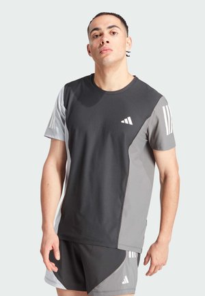 Camiseta atlética de color gris oscuro con detalles en gris claro, de manga corta, cuello redondo y tres franjas blancas en el hombro izquierdo.