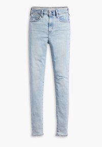 Jeans ajustados de color azul claro hechos de denim, con pequeños desgastes, una cintura alta, cinco bolsillos y un dobladillo deshilachado en el tobillo.