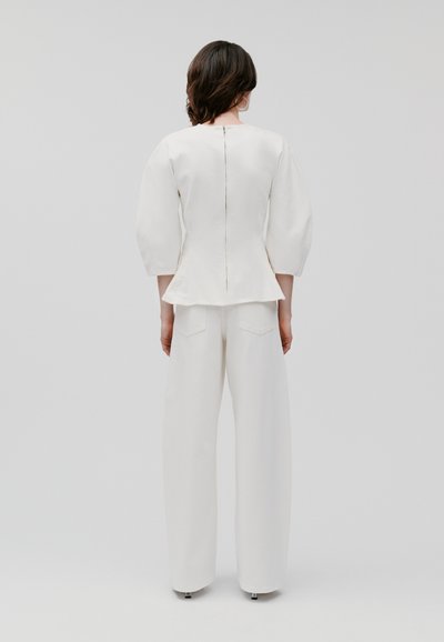 Weißes maßgeschneidertes Oberteil mit puffigen Ärmeln und Peplum-Taille, kombiniert mit weißen weit geschnittenen Hosen. Glatte Textur, minimalistisches Design.