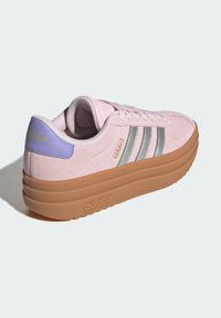 Adidas tenisice s gornjim dijelom od ružičastog nubuka, srebrnim trostrukim dizajnom, lavandastim naglaskom na peti i debelim gumiranim potplatom. Zaobljenog oblika nožnog prsta.