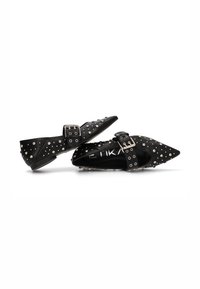 Bailarinas negras de punta afilada hechas de cuero suave, adornadas con tachuelas de metal, con una correa con hebilla sobre el empeine. Diseño de perfil bajo.