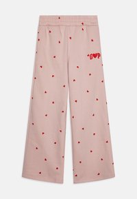 Rožinės plačios kelnės su laisvu siluetu, dekoruotos išsibarsčiusiais mažais raudonais širdelėmis ir raudonais siuvinėjimais „GOP“ kairėje pusėje.