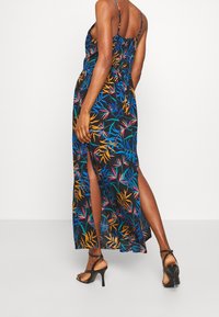 Maxiklänning i lätt tyg, med ett färgglatt blommönster på en svart bakgrund, smocksyd och sidov slit.