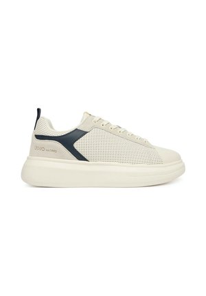 Sneaker beige low-top con lati traforati, dettaglio nero vicino al tallone, suola bianca spessa e design con lacci.
