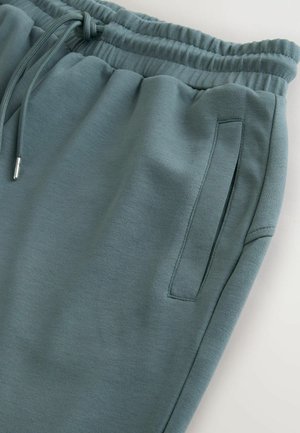 Light green sweatpants with a drawstring waist. Featuring a smooth texture, side pocket, and relaxed fit design. Premium fabric finish.