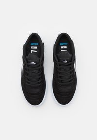 Black athletic shoes with mesh and suede materials, featuring a lace-up design, white rubber soles, and blue logo accents on the tongue.