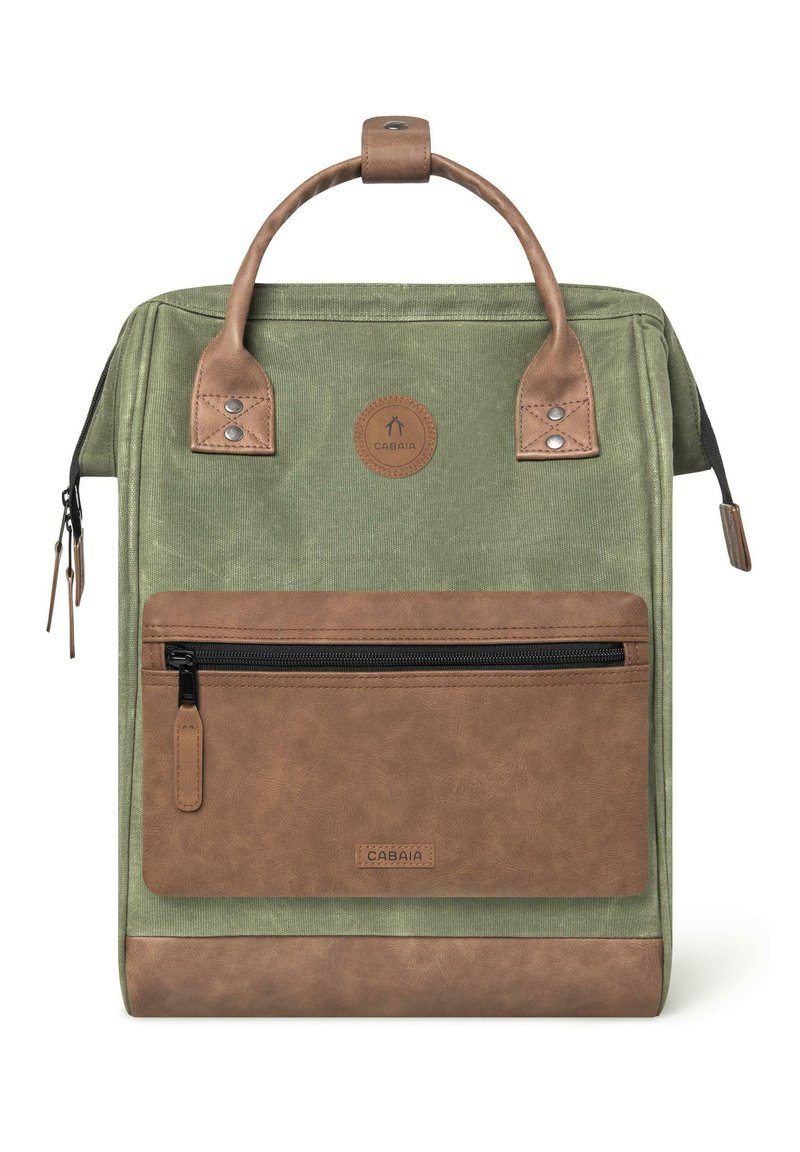 Zaino in tessuto verde con dettagli in finta pelle marrone, manico superiore, tasca frontale con zip e un'etichetta rotonda con logo. Superfici texture presenti.