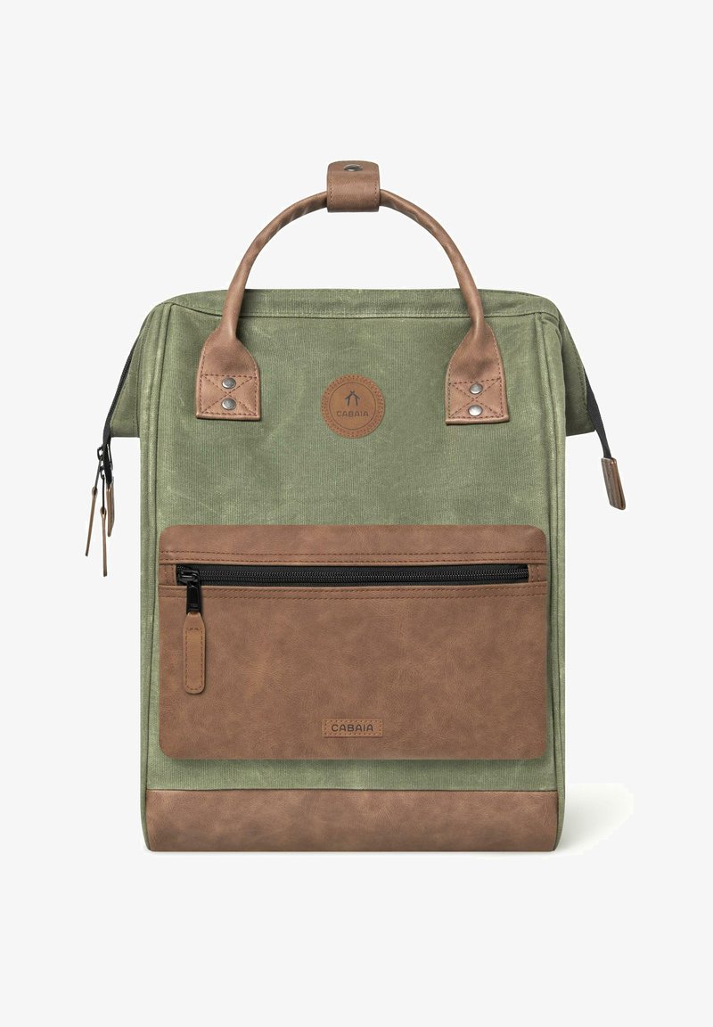Zaino in tessuto verde con dettagli in finta pelle marrone, manico superiore, tasca frontale con zip e un'etichetta rotonda con logo. Superfici texture presenti.