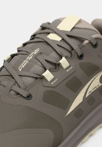 Lysbrune sneakers med tekstureret syntetisk overdel, meshpaneler og cremefarvede detaljer. Har flade snørebånd og en gummisål med gripmønstre.