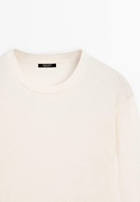 Krämfärgad tröja med rund halsringning och ribbad detaljering på kragen. Tillverkad av ett mjukt stickat material, med en etikett som visar "Massimo Dutti."