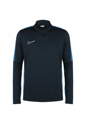 Granatowy sportowy top Nike z długim rękawem, z zamkiem do ćwiartki oraz jasnoniebieskimi paskami wzdłuż rękawów i boków.