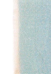 Sciarpa tessuta di colore azzurro chiaro con motivo a spina di pesce e bordo frangiato. Texture morbida con accenni di beige e fili blu più scuri.