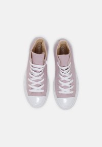 Höga sneakers i ljusrosa kanvas med vita snören och glänsande vita gummitåspetsar. Insidan har beige foder och varumärkelse.