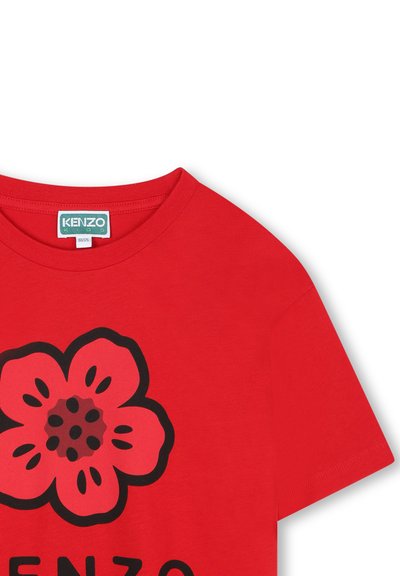 Czerwona bawełniana koszulka z okrągłym dekoltem i krótkimi rękawami, z dużą kwiatową grafiką w czerni i różu na przodzie.