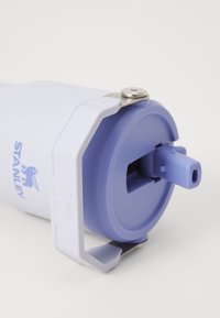 White insulated water bottle with a light purple lid. Features a push spout and a metal screw for securing a handle. STANLEY logo visible.