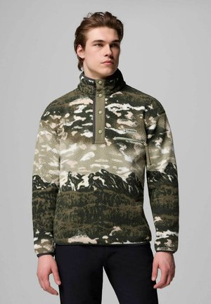 Fleece pullover in green camouflage pattern, featuring a high collar, snap buttons, and a zip pocket. Soft texture with nature-inspired design elements.