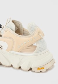 Baskets de sport pêche et gris avec une tige texturée, une semelle rembourrée et un branding prononcé. Comprend des panneaux en mesh et une semelle épaisse et robuste.