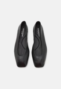 Ballerines en cuir noir avec un bout carré et un design minimaliste. Texture lisse avec un intérieur doux et un logo de marque subtil sur la semelle intérieure.