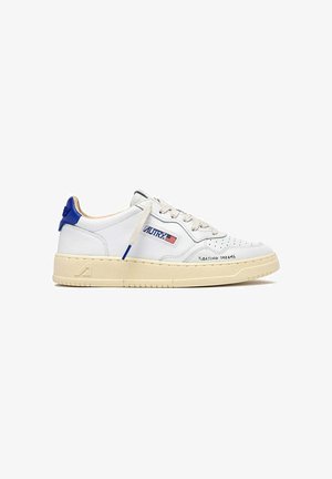 Zapatilla deportiva blanca de cuero con lengüeta azul en el talón, suela beige, logo "AUTRY" con la bandera de EE.UU. y texto "FLOATING DREAMS" cerca de la puntera.