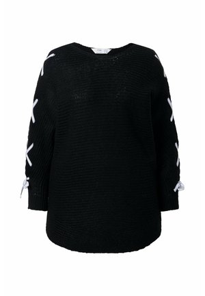 Schwarzer Strickpullover mit weißen Rippenschnürungen, die in einem Kreuzmuster an den Ärmeln verlaufen, sowie gebundenen Schleifen nahe den Handgelenken.