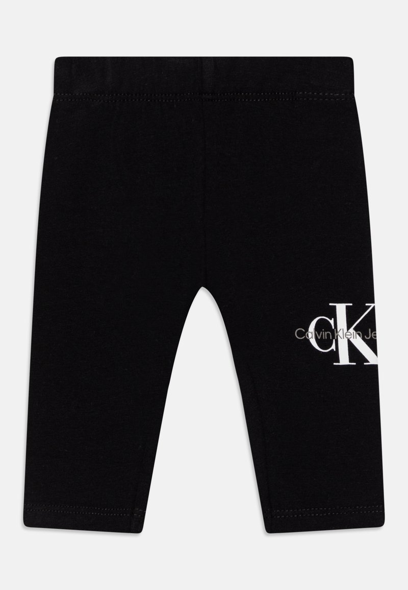 Svarta leggings tillverkade av mjukt material, med en vit "CK" logotyp och text på nedre sidan. Midje med hög mittpunkt och elastiskt band.