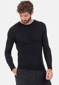 Schwarzer Pullover mit langen Ärmeln in tailliertem Design, gefertigt aus einem weichen Material. Rundhalsausschnitt und gerippte Bündchen. Glatte Textur, keine Muster oder Akzente.