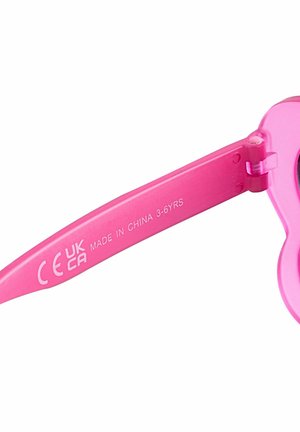 Rozā plastmasas saulesbrilles ar sirds formas lēcām. Rāmja daļā ir apdrukāts teksts: "CE UK CA MADE IN CHINA 3-6GADU VECUMĀ". Gluda tekstūra.