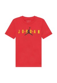 Červené bavlněné tričko s černým logem Jumpman a textem „JORDAN“ v žluté barvě napříč hrudníkem. Klasický design s krátkým rukávem.