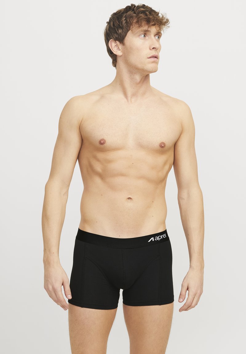 Black boxer shorts with a wide elastic waistband featuring a logo, constructed from a smooth fabric, fitted design, mid-thigh length.