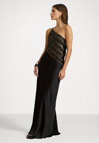 Μαύρο βραδινό φόρεμα με εφαρμοστή σιλουέτα, σχέδιο ενός ώμου και κορσέ με παγιέτες που διαθέτει χρυσές ρίγες. Λείος υφασμάτινος χαρακτήρας.
