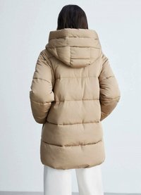 Lichtbruine pufferjack met een capuchon, met gewatteerde secties en elastische manchetten. Gladde, gevoerde textuur die warmte en bedekking biedt.
