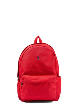 Zaino rosso con tasca anteriore con cerniera e manico superiore, con un piccolo logo ricamato blu sul pannello frontale superiore.