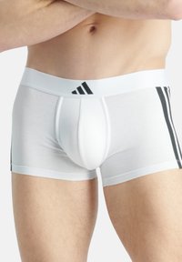 Weiße Baumwollboxershorts mit schwarzen seitlichen Streifen und Bund. Mit einem konturierten Beutel und einer glatten Textur. Adidas-Logo am Bund.