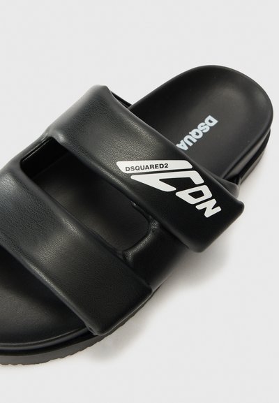 Infradito neri con due cinghie più larghe, materiale sintetico testurizzato, con branding bianco "DSQUARED2 ICON". Suola piatta, design minimalista.