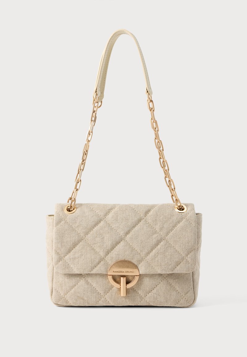 Sac bandoulière matelassé beige avec des chaînes dorées en guise de bandoulière, une poignée en cuir et un fermoir circulaire doré, sur un fond uni.