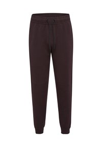 Mörkbruna sweatpants med elastisk midja, dragsko-detalj, sidofickor och smalnande ben. Tillverkade av mjukt tyg med en slät textur.