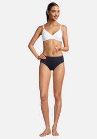 Reggiseno bianco imbottito con spalline regolabili abbinato a slip bikini a vita alta blu navy. Tessuto morbido e cuciture minime per il massimo comfort.