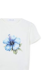 T-shirt bianca a maniche corte con una grande grafica di un fiore di ibisco blu, con petali dettagliati e foglie verdi. Etichetta del marchio visibile.