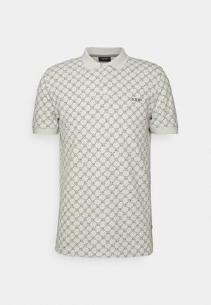 Beige polo shirt with a repeating circular pattern, short sleeves, a collar, and an embroidered logo on the left chest. Cotton material.