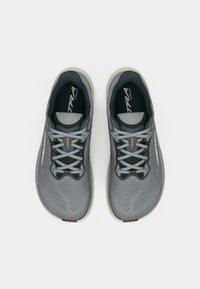 Gray running shoes with a textured mesh upper, contrasting laces, and a lightweight sole. Features subtle branding and an orange accent.