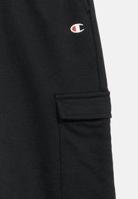 Μαύρο βαμβακερό παντελόνι φόρμας με πλαϊνή τσέπη με καπάκι και μικρό λευκό και κόκκινο λογότυπο στο αριστερό μηρό.