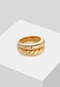 Bague en or présentant un dessus lisse et arrondi avec un détail de bande torsadée, mettant en valeur une finition polie et une texture réfléchissante.