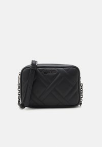 Czarna pikowana torebka na ramię o prostokątnym kształcie, wykonana z gładkiej skóry. Posiada odpinany pasek i logo Calvin Klein na przodzie.