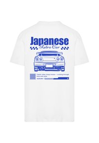 White cotton t-shirt featuring a blue graphic of a retro Japanese car and text. Design includes checkered patterns and horizontal bars.