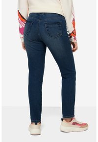 Tmavě modré džíny s slim fit, s klasickým designem pěti kapes a drobným opotřebením na zadních kapsách.