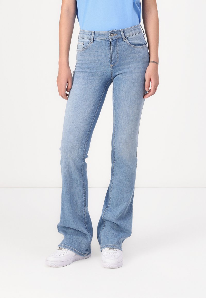 Ljust blå flare-jeans i denim, med en klassisk femfickdesign, bältesslingor och subtil blekning längs benen.