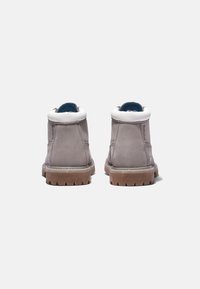 Botas de tobillo de cuero gris con forro de piel blanca, suela de goma y un forro interior azul en contraste, que presentan un diseño sencillo y redondeado.
