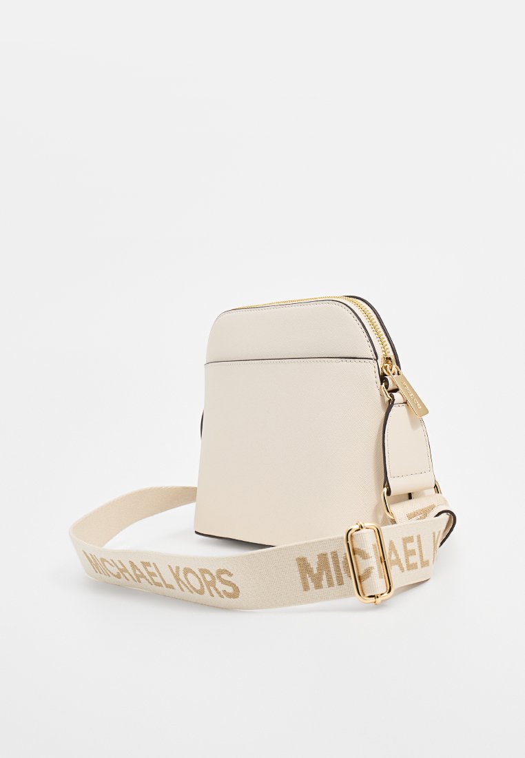 Bolso bandolera de cuero sintético crema con herrajes dorados, cierre de cremallera y una correa beige de marca con hebilla.