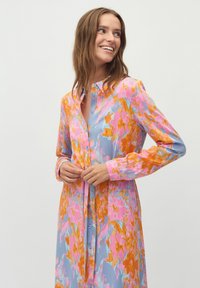 Langärmliges Hemdkleid in Blau mit einem floralen Muster in Rosa und Orange. Verfügt über eine Knopfverschluss und eine lässige Passform. Weicher, leichter Stoff.